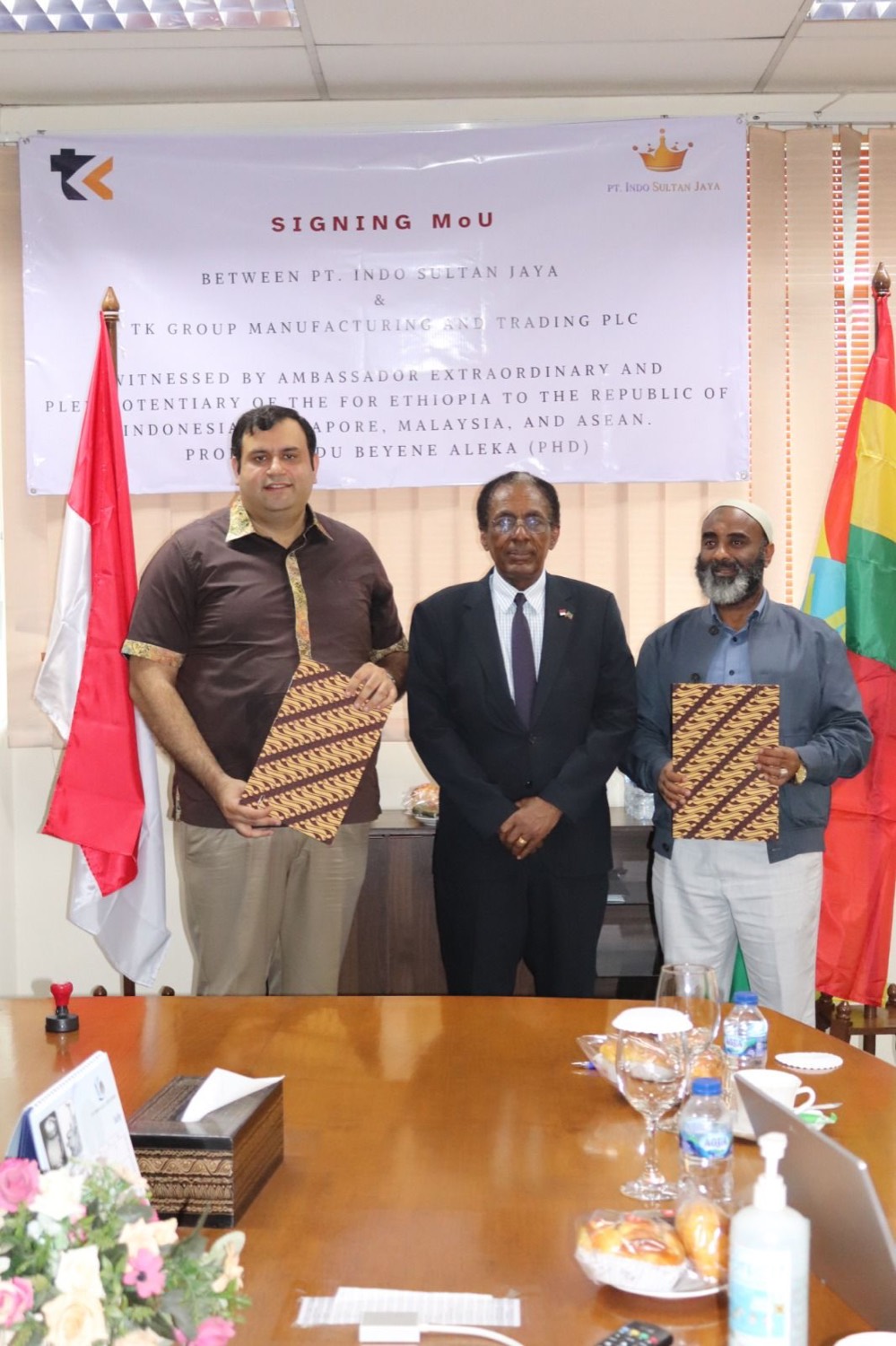 PT Indo Sultan Jaya and TK Group of Ethiopia with the Ethiopian Ambassador after signing the MoU, beneath the signing banner and the Indonesian and Ethiopian flags